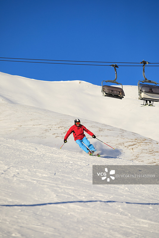 滑雪冬季运动。男子滑雪者在阳光明媚的滑雪胜地享受滑雪。多洛米蒂超级滑雪区的雪山。图片素材