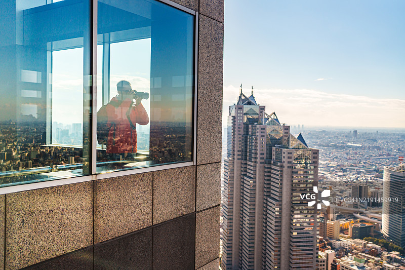 在东京市政府大楼的摄影师，透过窗户拍摄城市景观。图片素材