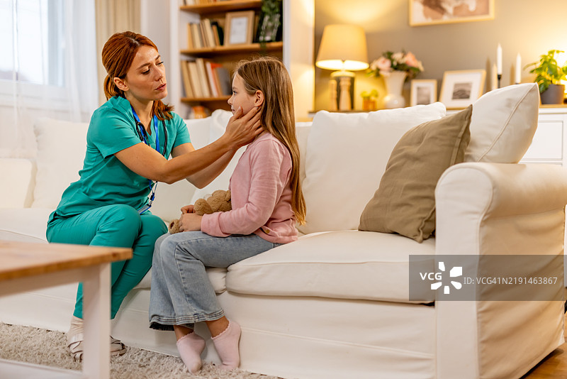 护士在温馨的客厅里安慰一个年轻的孩子坐在沙发上图片素材