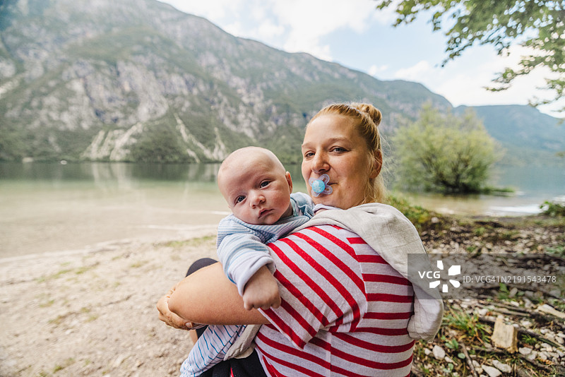 白人母亲与婴儿男孩享受湖边风景图片素材