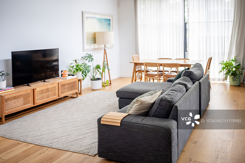 带有餐区和大型灰色沙发的客厅。图片素材