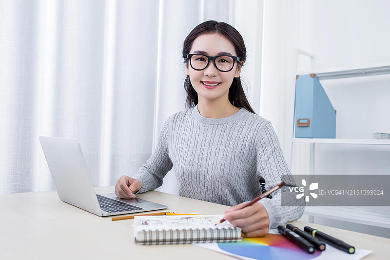 亚洲女性在桌子上进行设计项目工作图片素材