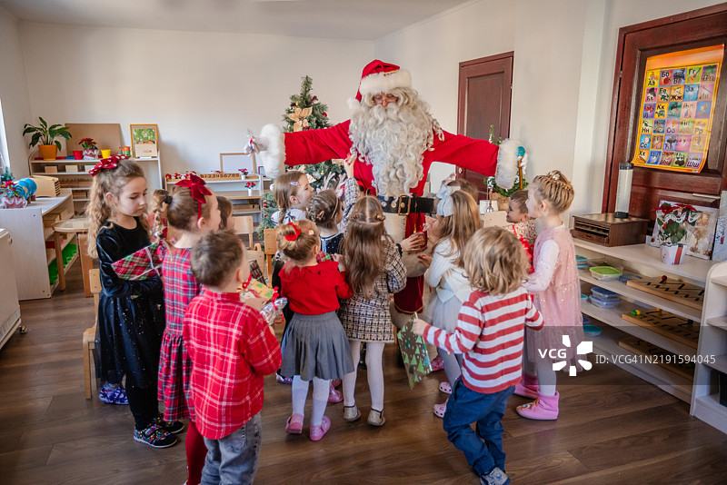 圣诞老人和孩子们在课堂上进行有趣的游戏。图片素材