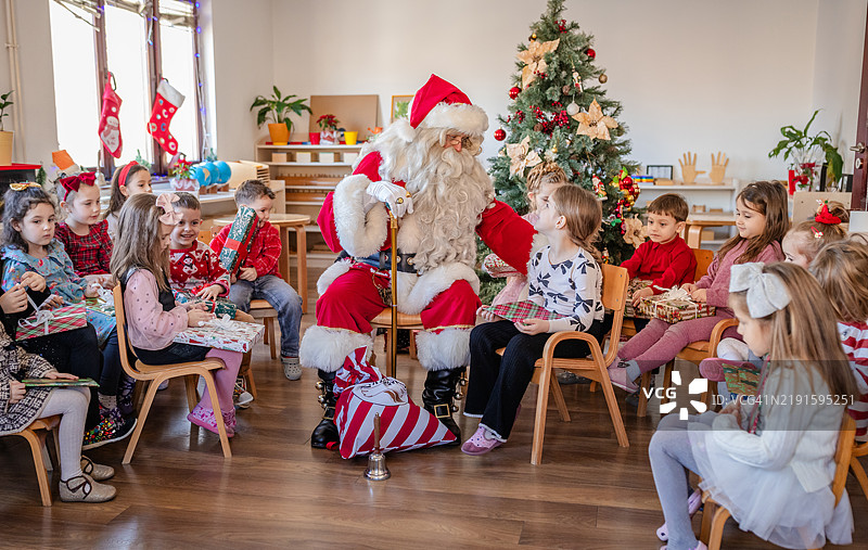 圣诞老人参与假期课堂活动，与孩子们互动图片素材