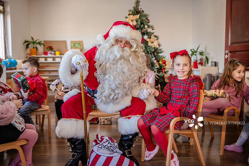 圣诞老人和孩子们在节日中分享快乐时光。图片素材
