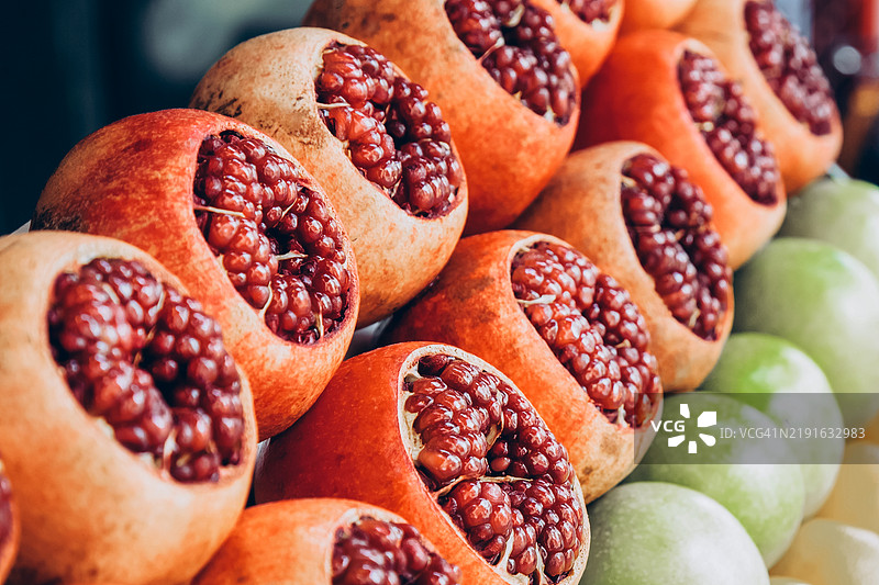 在街头农贸市场出售石榴、苹果和橙子。图片素材