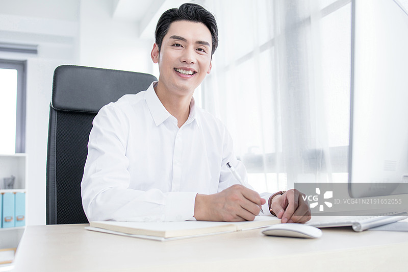 商务人士在办公室使用笔记本电脑工作图片素材