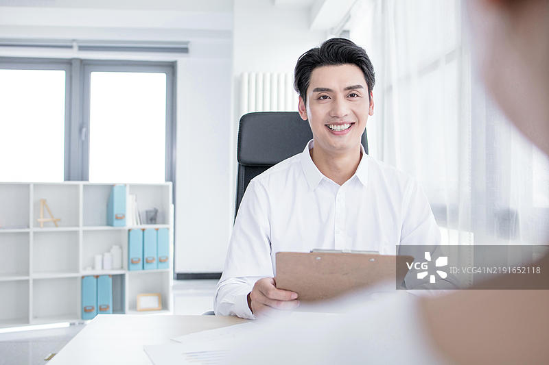 自信的商人与同事讨论工作图片素材