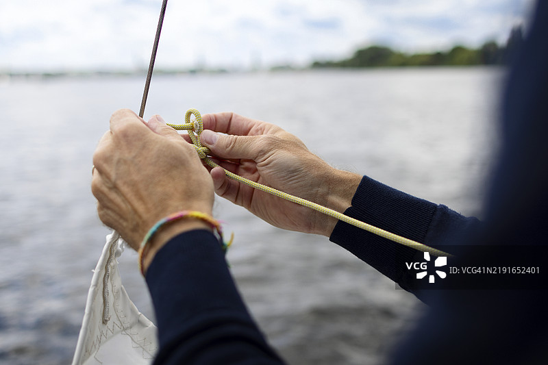 特写镜头下的男子在打水手结图片素材