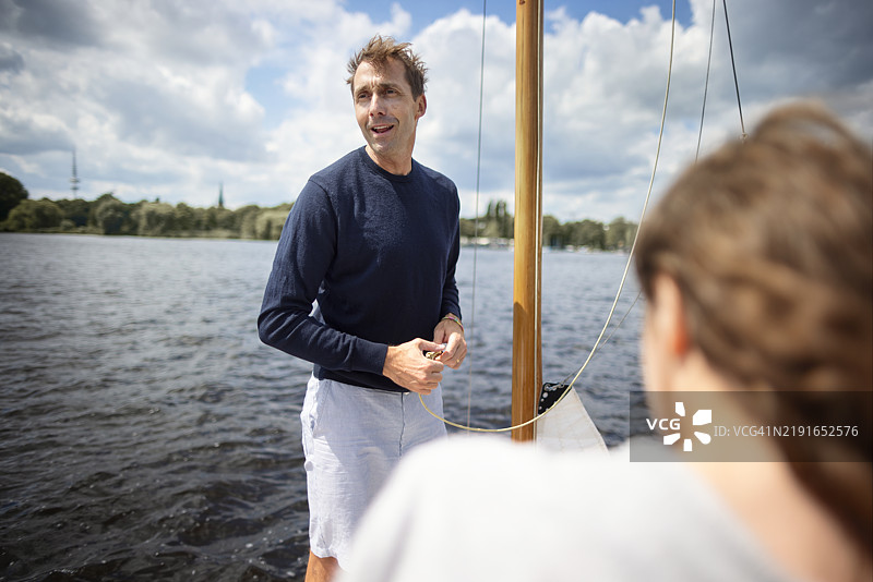 父亲和女儿在帆船上四处张望图片素材