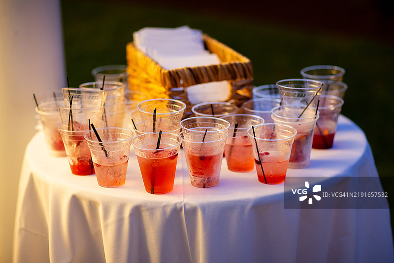 派对结束时桌子上的塑料杯红色饮料图片素材