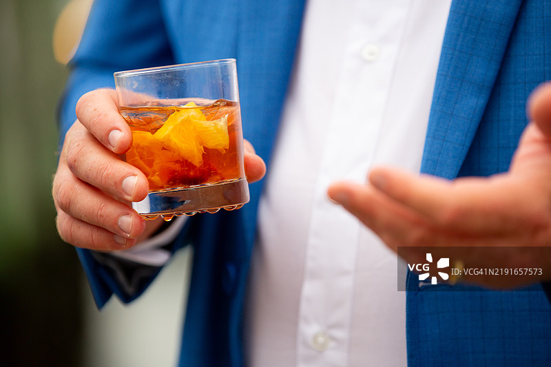 男人手持樱桃橙味复古鸡尾酒图片素材