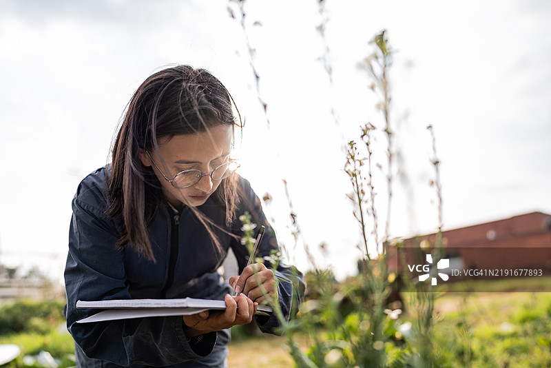 温室内的农民工在笔记本上写字图片素材