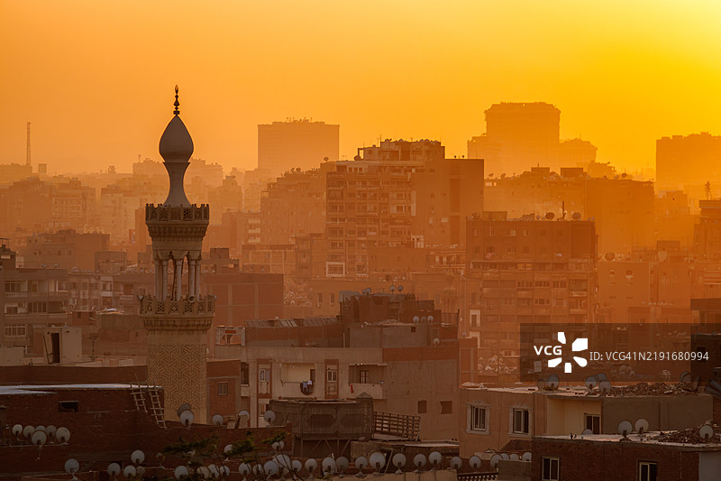 开罗日落时分的城市景观与清真寺尖塔图片素材