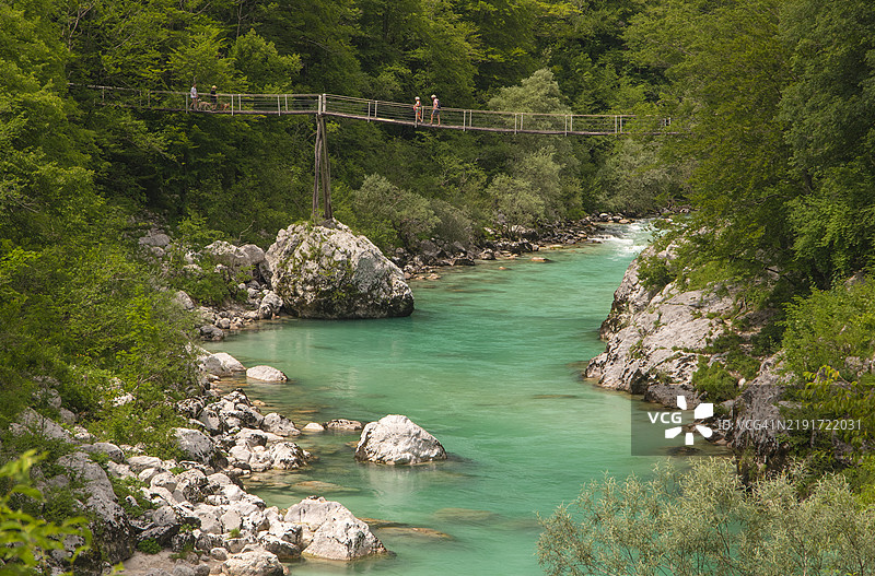 人们在斯洛文尼亚戈里什卡的科巴里德，穿过一座木制人行桥，横跨索恰河。图片素材