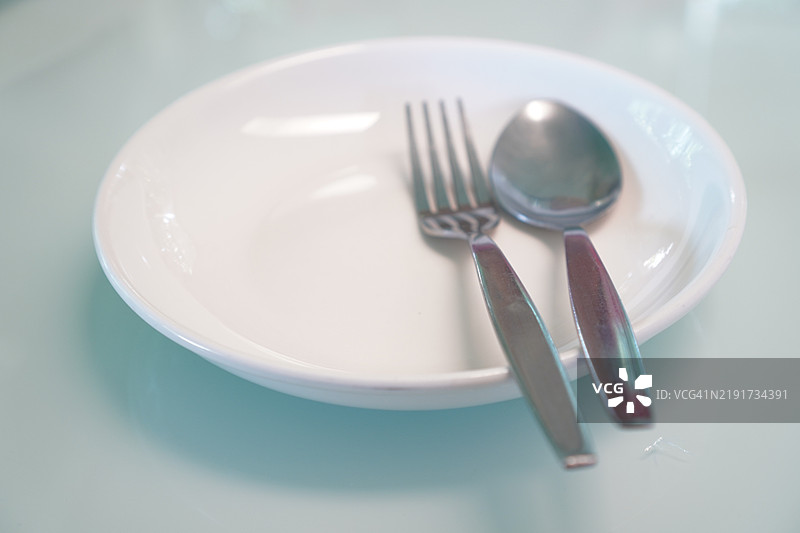 白色盘子上的勺子和叉子图片素材