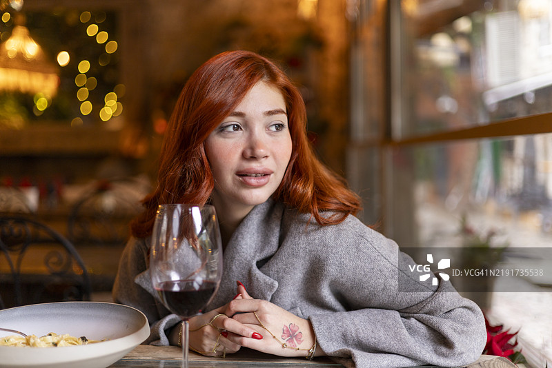 年轻女性在餐厅里喝红酒并等待图片素材