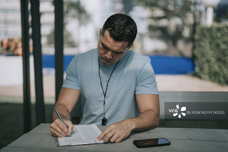 澳大利亚男性教练为网球队制定战术计划图片素材