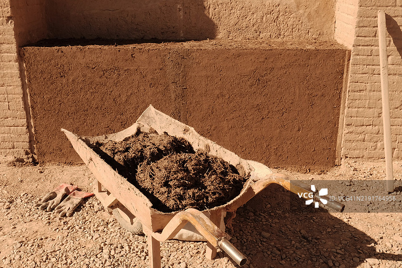 伊朗巴姆城堡前的工人手推车与土坯墙图片素材