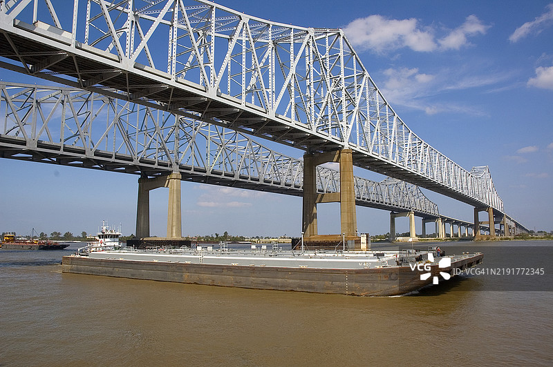 密西西比河新奥尔良的弯月城连接桥下驶过的驳船图片素材