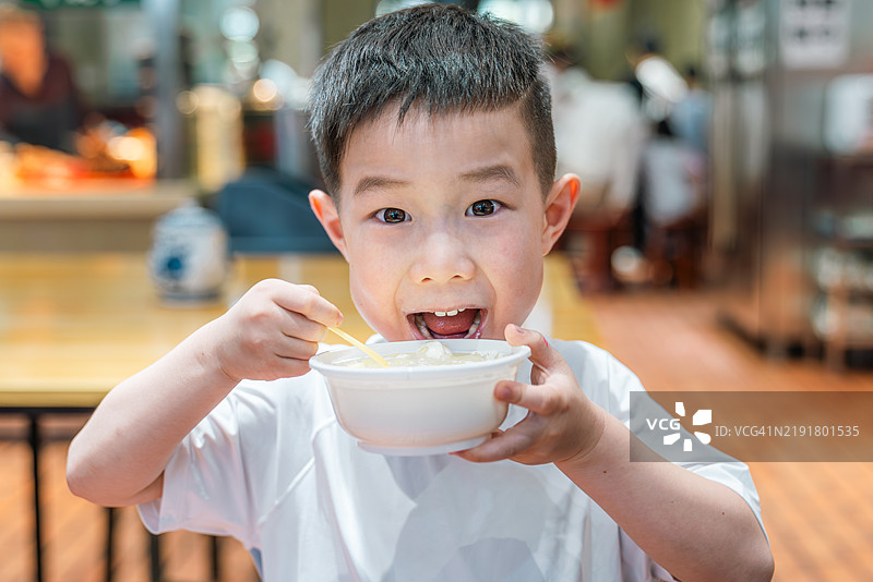 男孩在碗里吃东西图片素材