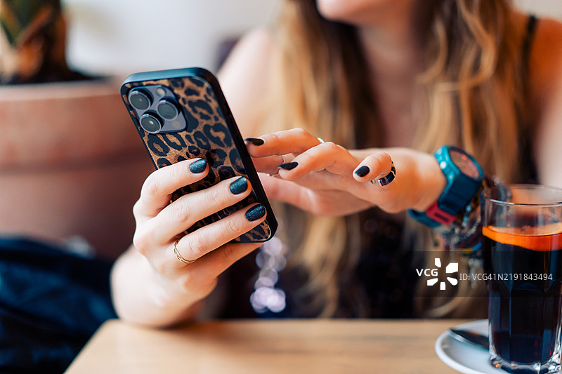咖啡馆里使用智能手机的女性图片素材