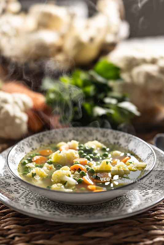 春季蔬菜汤，配有春葱、胡萝卜、花椰菜和青豌豆，调味以新鲜的香菜图片素材