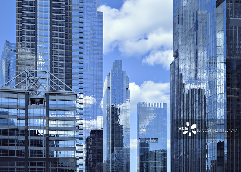 蓝天与积云在芝加哥镜面玻璃办公大楼的外立面上反射图片素材