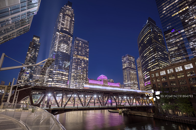 黄昏时分，芝加哥市中心灯火辉煌，地铁列车穿过湖街桥和芝加哥河。图片素材
