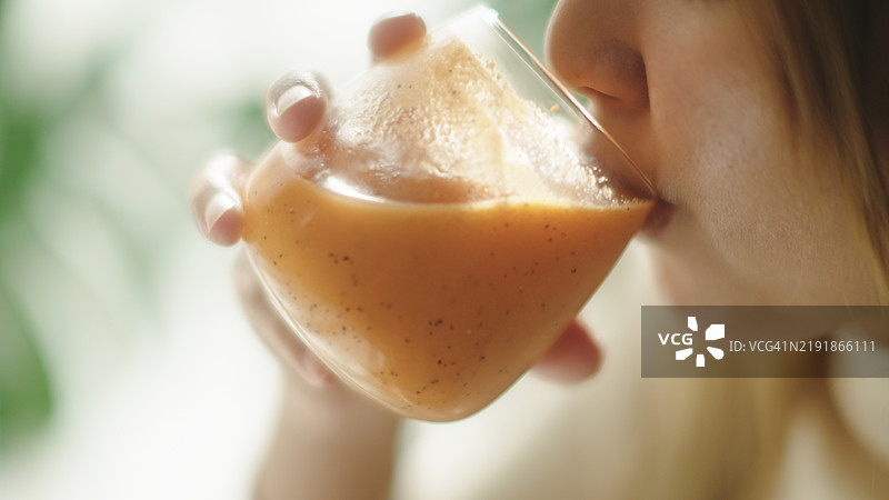 女人在喝果昔汁。图片素材
