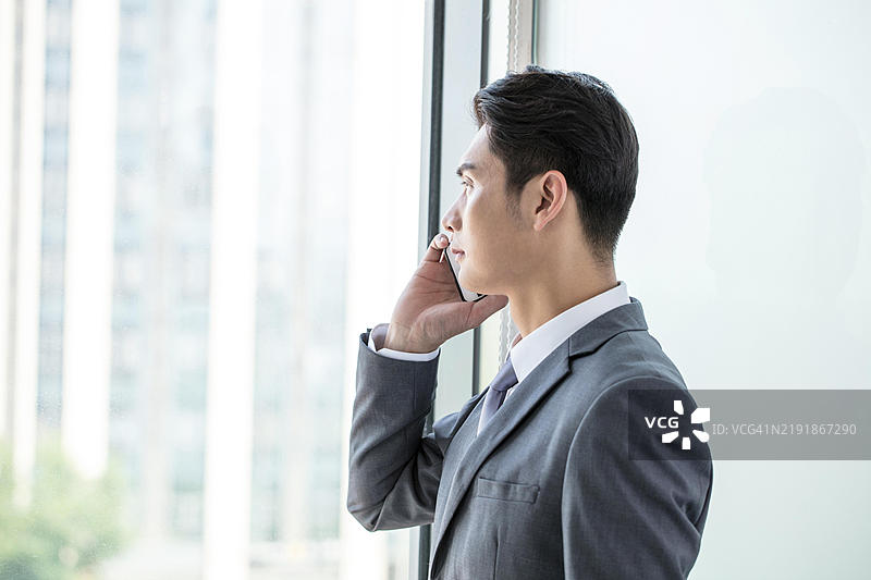 身穿西装的商人在办公室里打电话图片素材