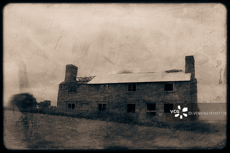 一个阴森的废弃腐朽农舍，位于乡村，带有复古的磨损效果。图片素材