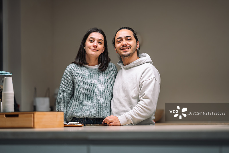 两位年轻的咖啡师在咖啡店的柜台前微笑图片素材