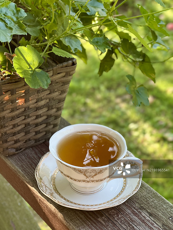 木质露台栏杆上的瓷茶杯竖直照片图片素材