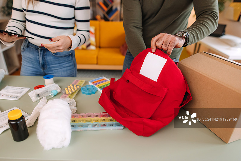 男女准备应急物品，包括急救包和药物。图片素材
