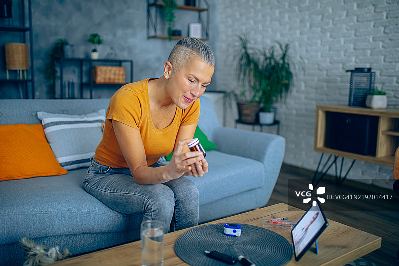 女性手持药丸，使用科技进行远程医疗预约图片素材