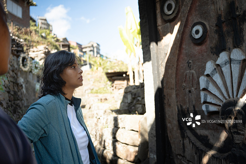 年轻女性旅行者在孔诺玛向导游学习关于安加米部落的知识。图片素材