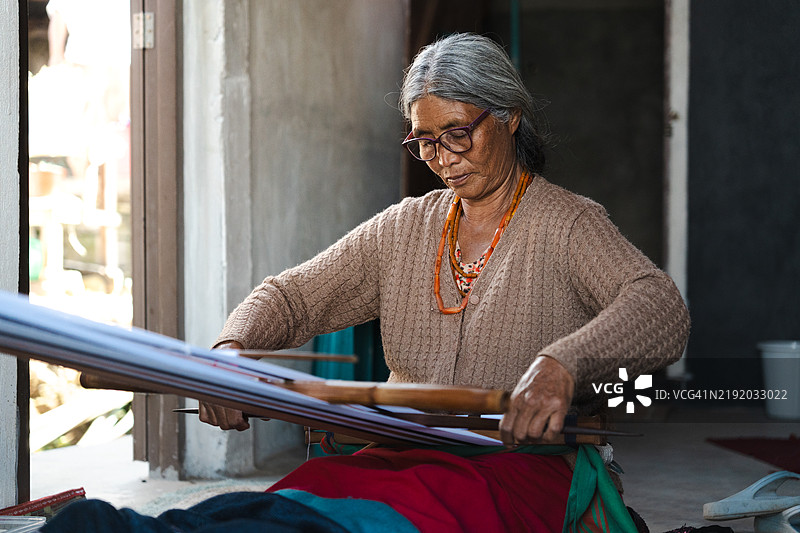 老年女性编织传统披肩。图片素材