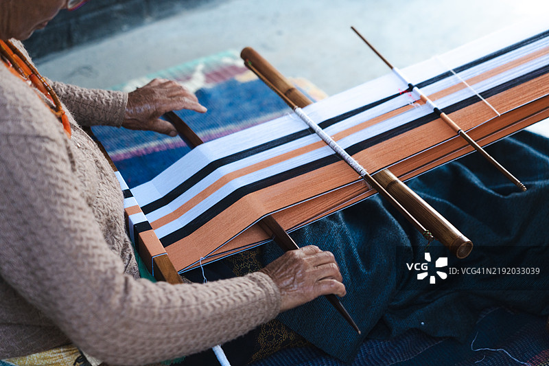 老年女性编织传统披肩。图片素材