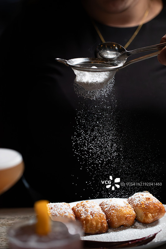 油炸甜甜圈面团，撒上糖粉，配浆果酱。图片素材