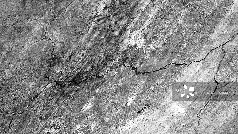 凹陷且风化的混凝土墙上的裂缝特写。粗糙的纹理。黑白色调。阳光。法国,上萨瓦省,埃维昂-莱-班。图片素材