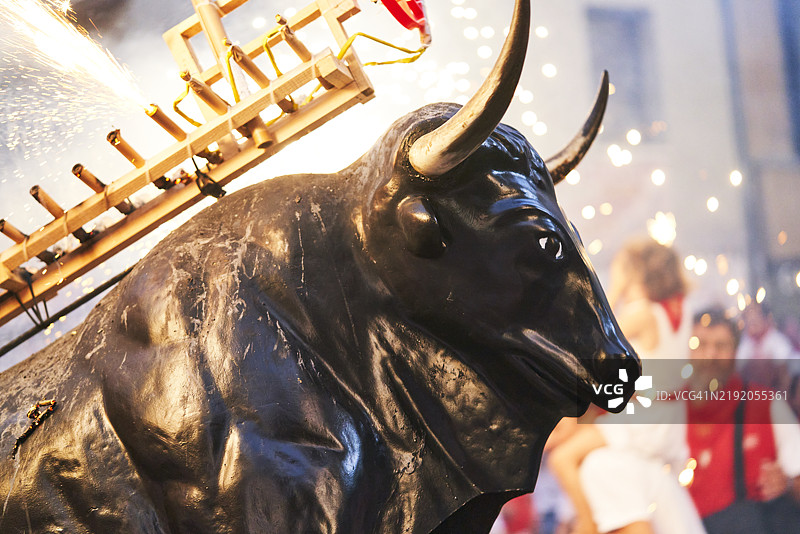在潘普洛纳的圣费尔明节庆祝活动中，黑牛的侧面与烟花相映成趣。图片素材