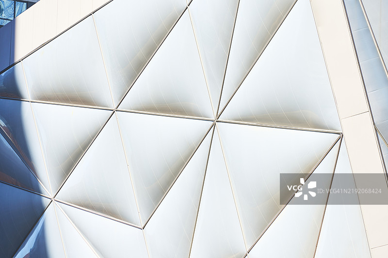现代建筑外观，三角形玻璃面板反射阳光图片素材