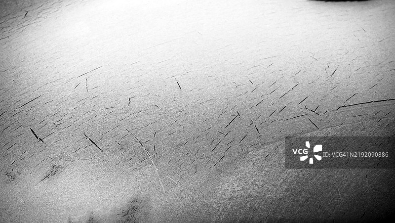 特写镜头,冰霜覆盖在汽车挡风玻璃上。前景清晰。黑白色调。阳光与阴影。法国,上萨瓦省,埃维昂莱班。图片素材