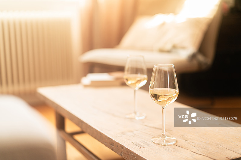 家中乡村风格的木桌上放着两杯白葡萄酒图片素材