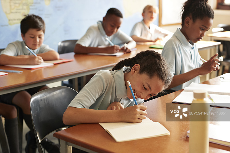 微笑的女孩在书中写字图片素材