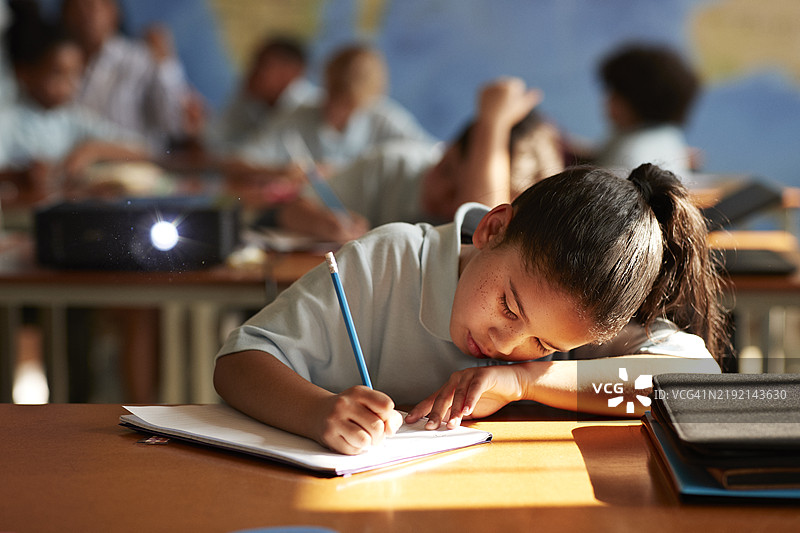 扎着马尾辫的女学生在书中写字图片素材