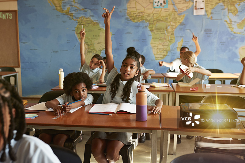 女孩在课堂上举手回答问题图片素材