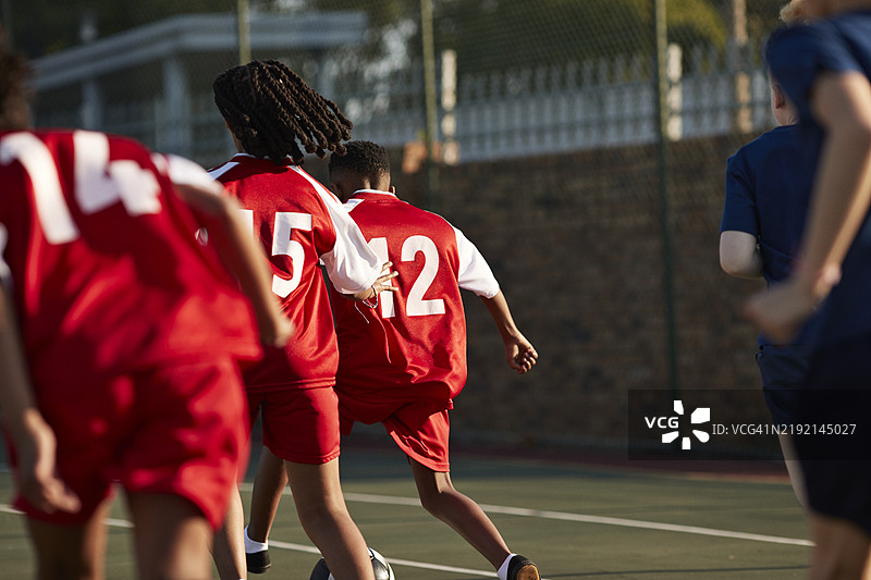 穿着球衣的学生们在踢足球图片素材