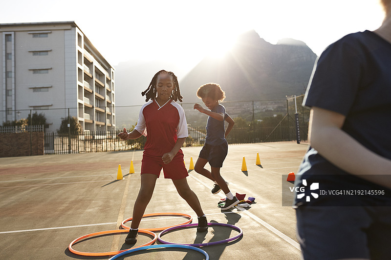 女孩在学校操场上玩圈圈图片素材